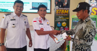 Ketua RT memegang HP bantuan program digitalisasi desa Margasari