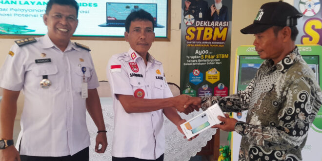 Ketua RT memegang HP bantuan program digitalisasi desa Margasari